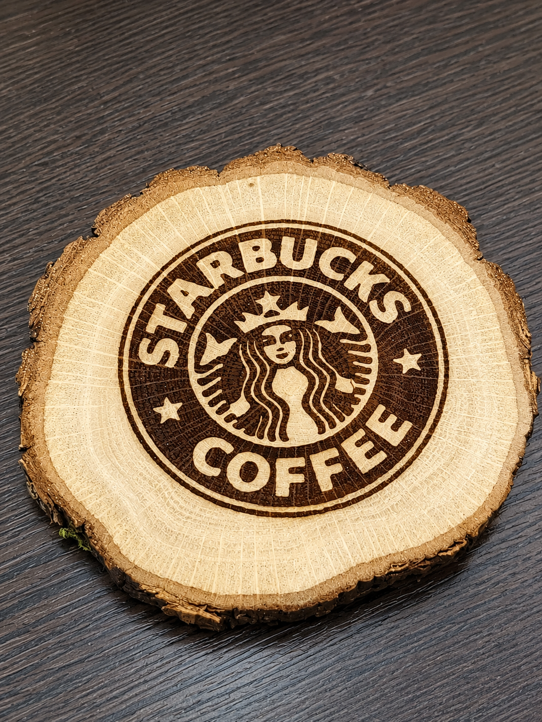 Дерев'яний зріз із лазерним гравіюванням логотипа Starbucks.